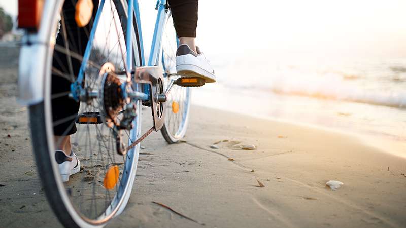 A person riding a bike on the beach
