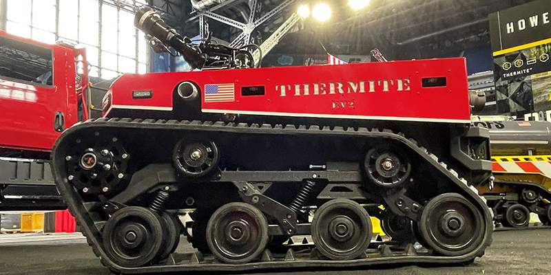 Thermite EV2 red vehicle at FDIC tradeshow, Howe & Howe products Big Dog and Thermite RS1 in background